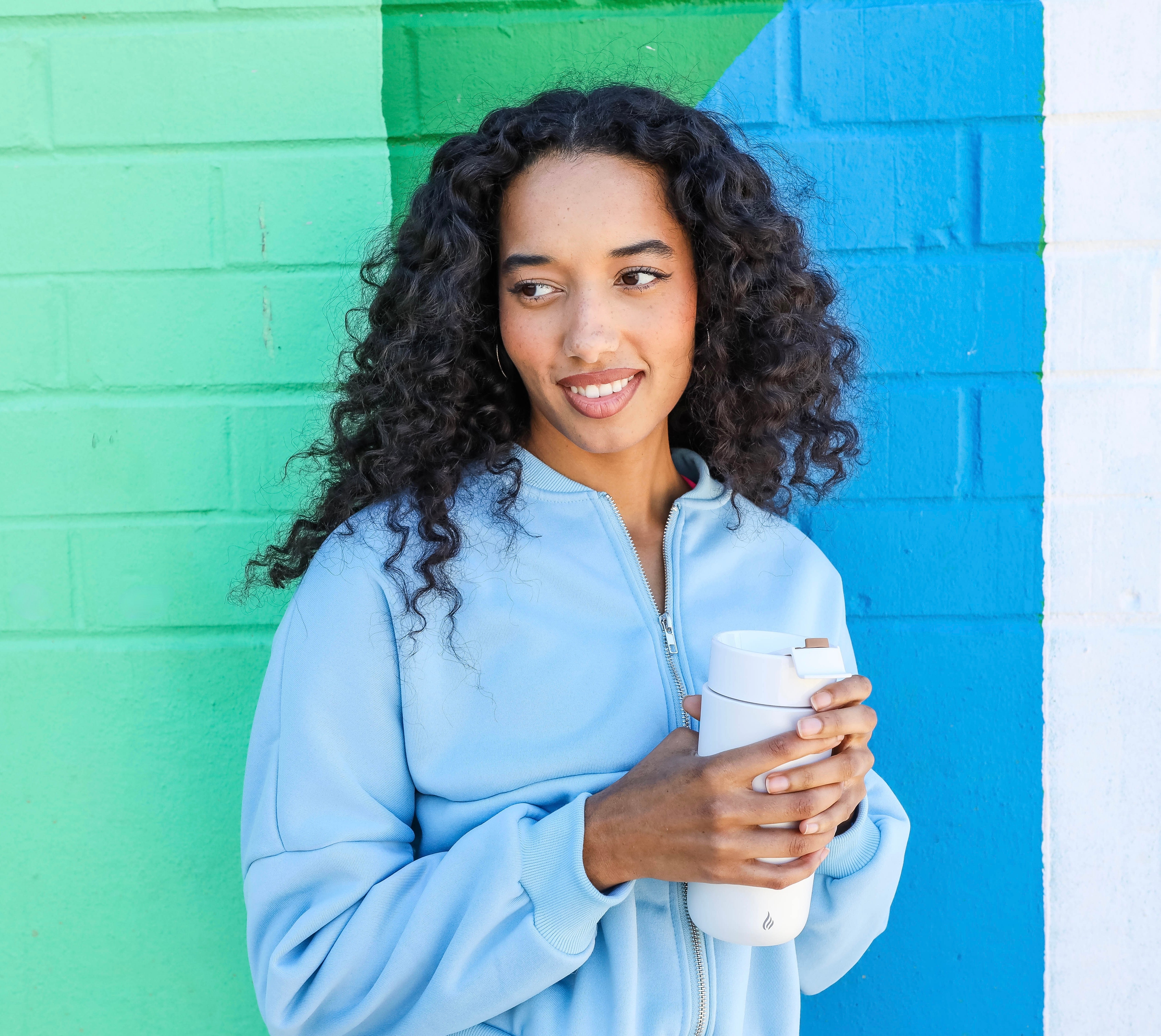 A woman holding the Ciups® GoMug outdoors 