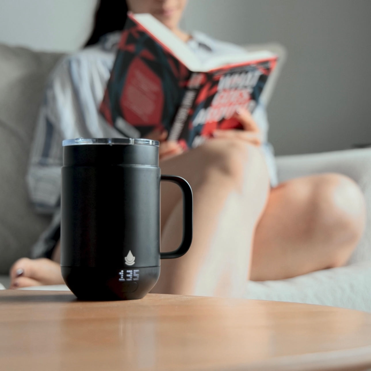 Reading a book while the Ciups Mug maintains your drinks heat